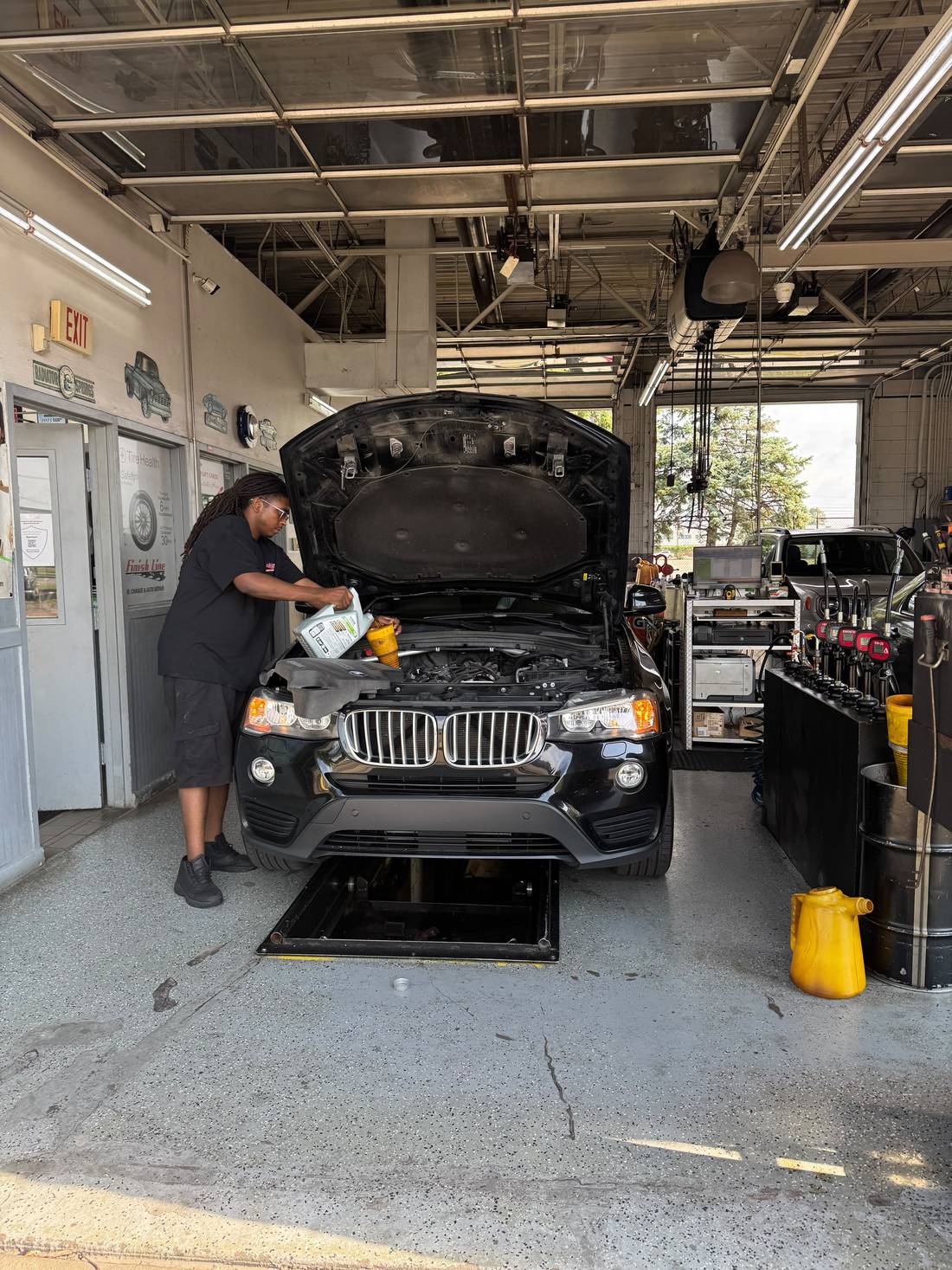Finish Line technician pouring fresh oil into a vehicle engine during a fleet oil change